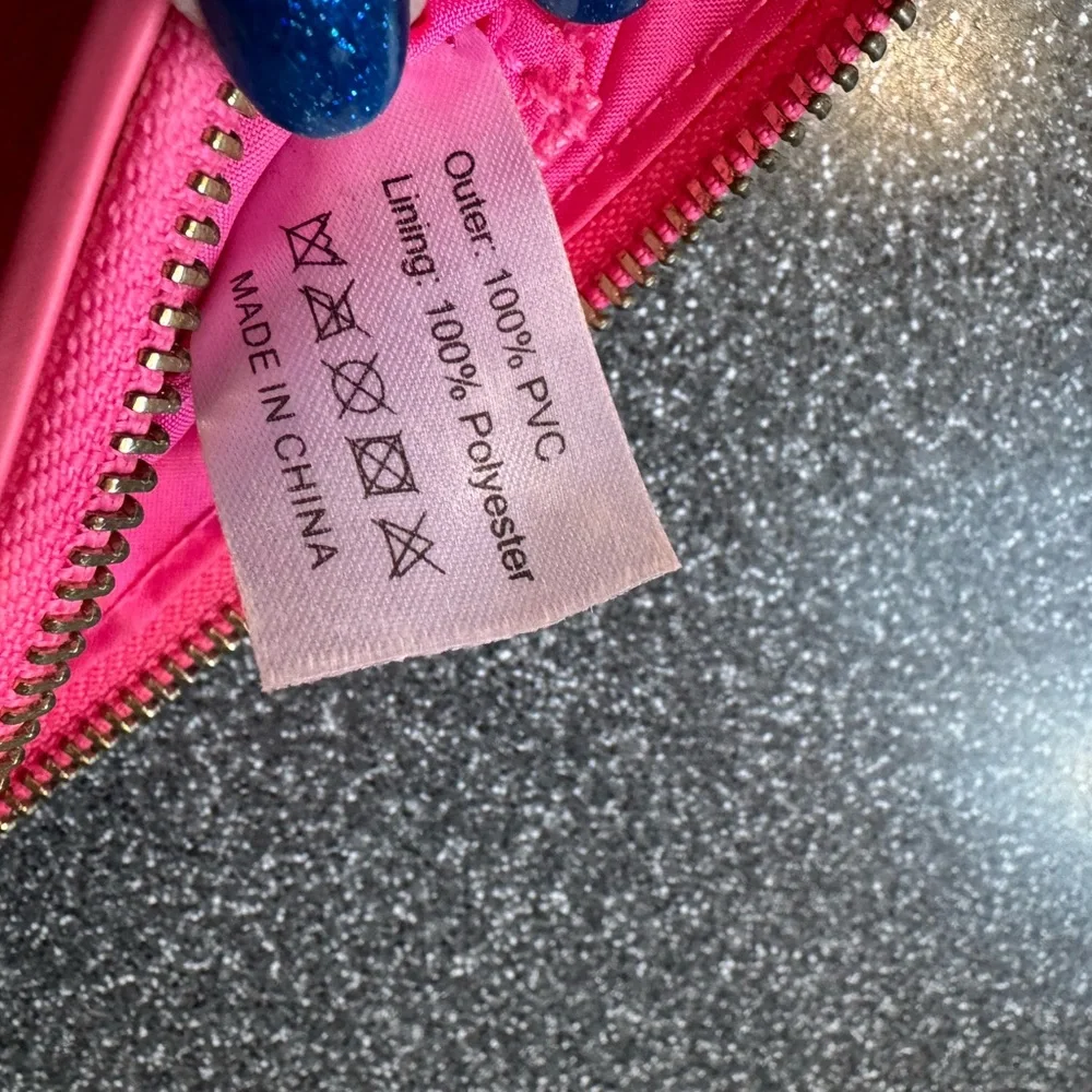Pink cosmetics bag with 🐝 emblem. Has two inside pockets.